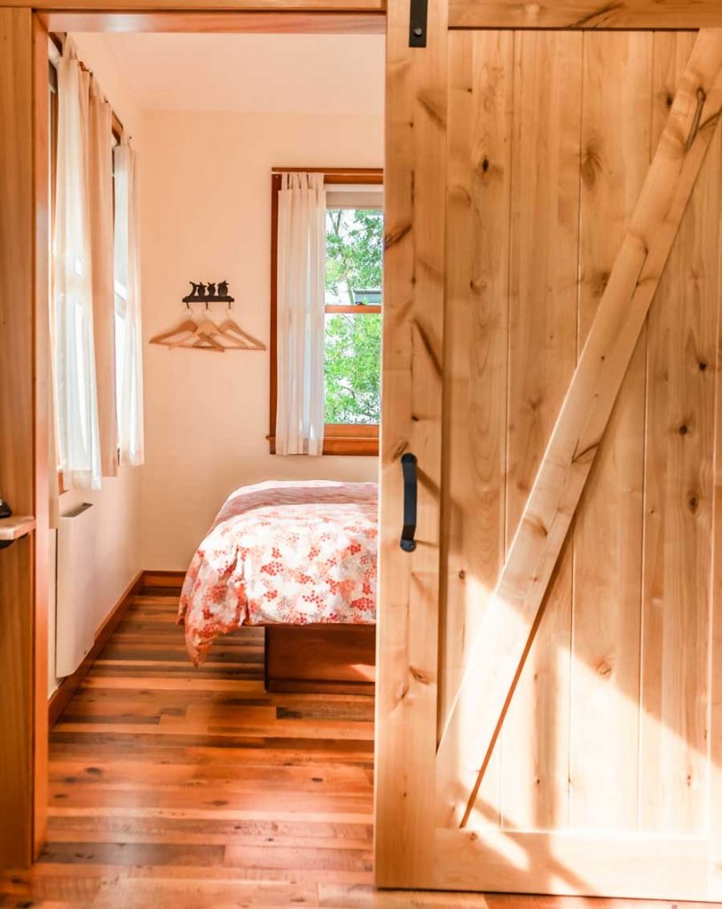 bed with slider door and wooden floors